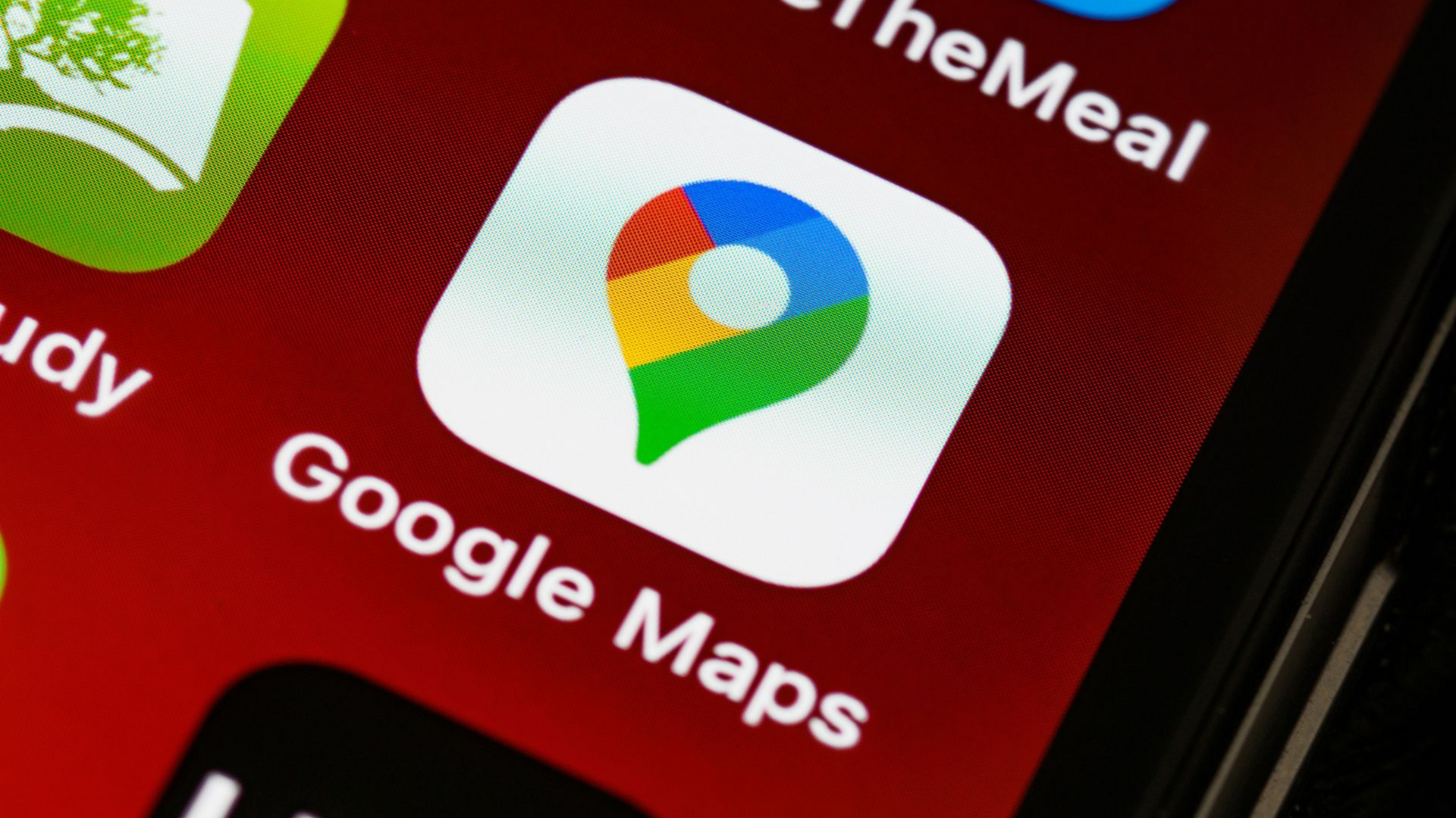 Close-up of smartphone app icons, including Google Maps on a red screen.