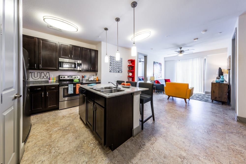 Open layout kitchen with a large island in the middle and stainless steel appliances at Regents West at 24th in Austin, TX, near West Campus.
