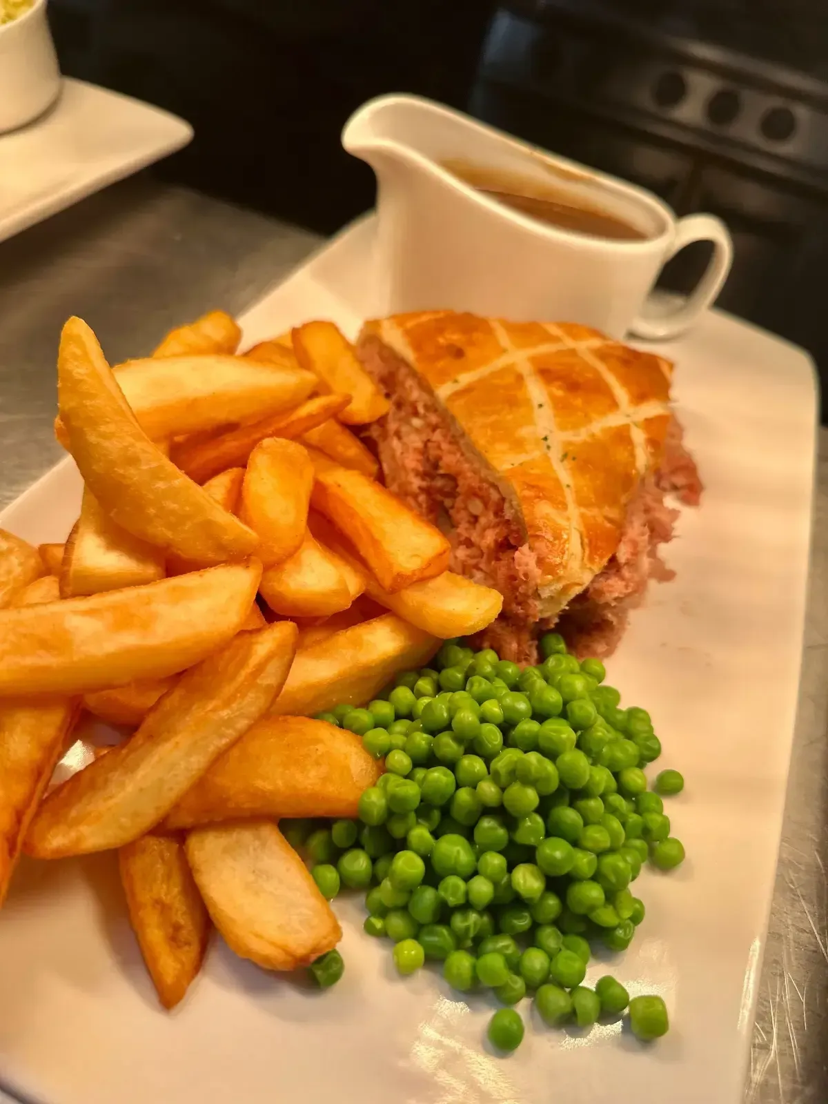 The Mackworth Arms, Laleston, Bridgend | Plate of food: meat pie with chips, peas, and gravy.
