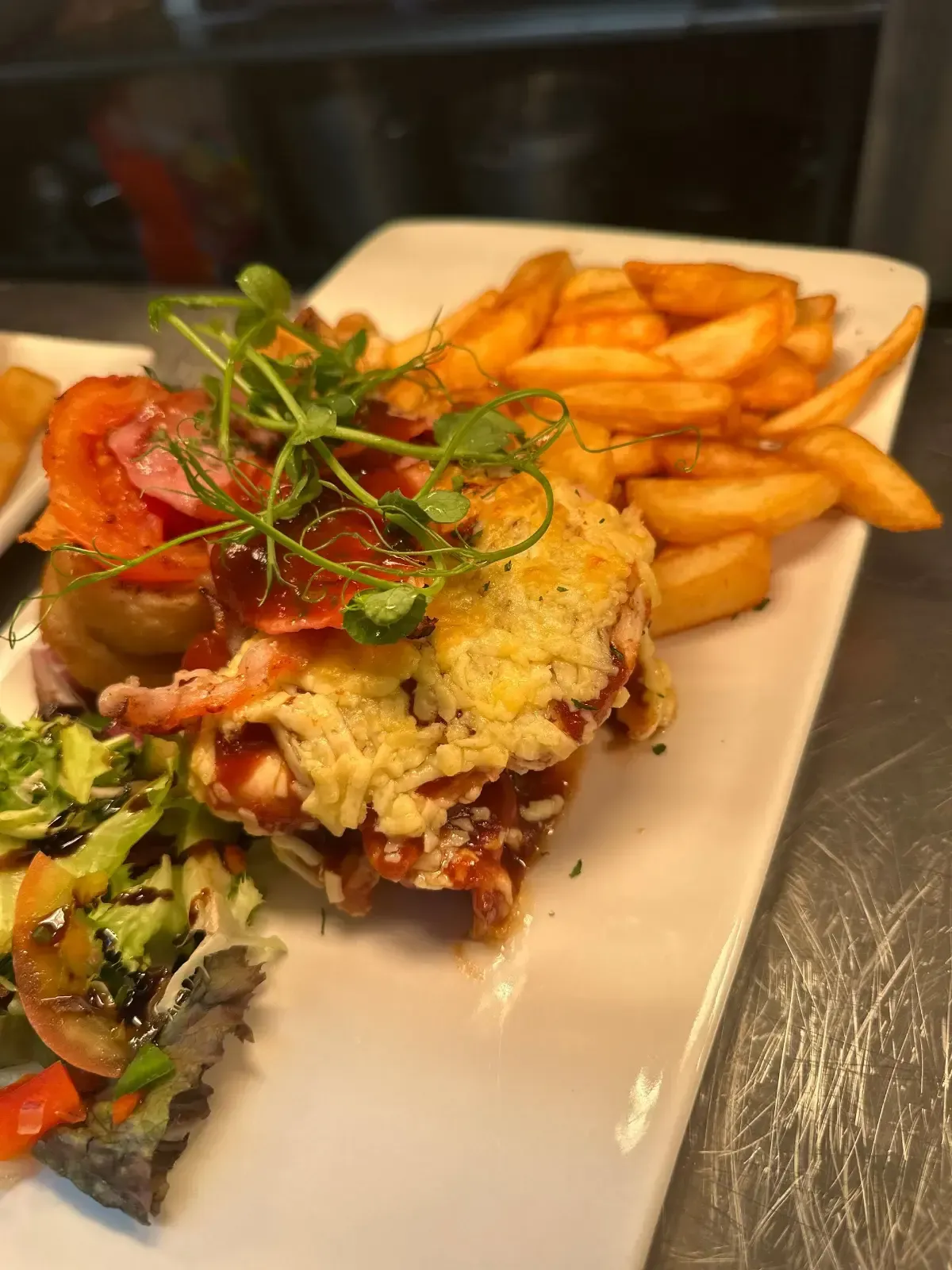 The Mackworth Arms, Laleston, Bridgend | Chicken dish with fries and salad on a white rectangular plate.
