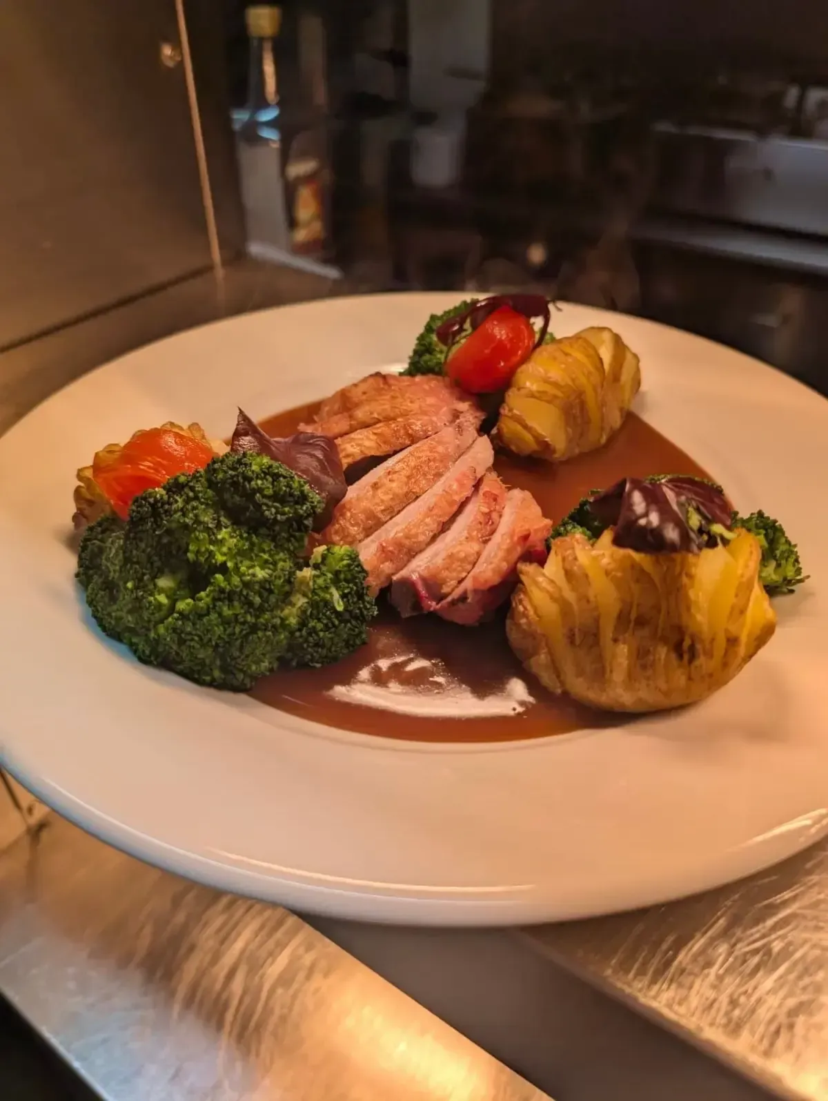 The Mackworth Arms, Laleston, Bridgend | Sliced duck breast with vegetables and gravy on a white plate.