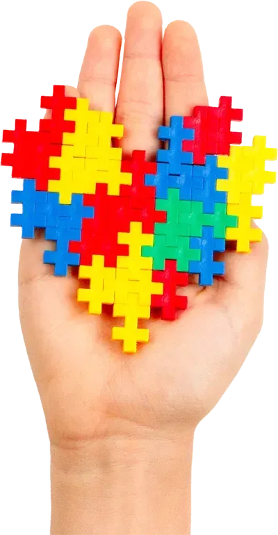 A hand is holding a heart made of puzzle pieces