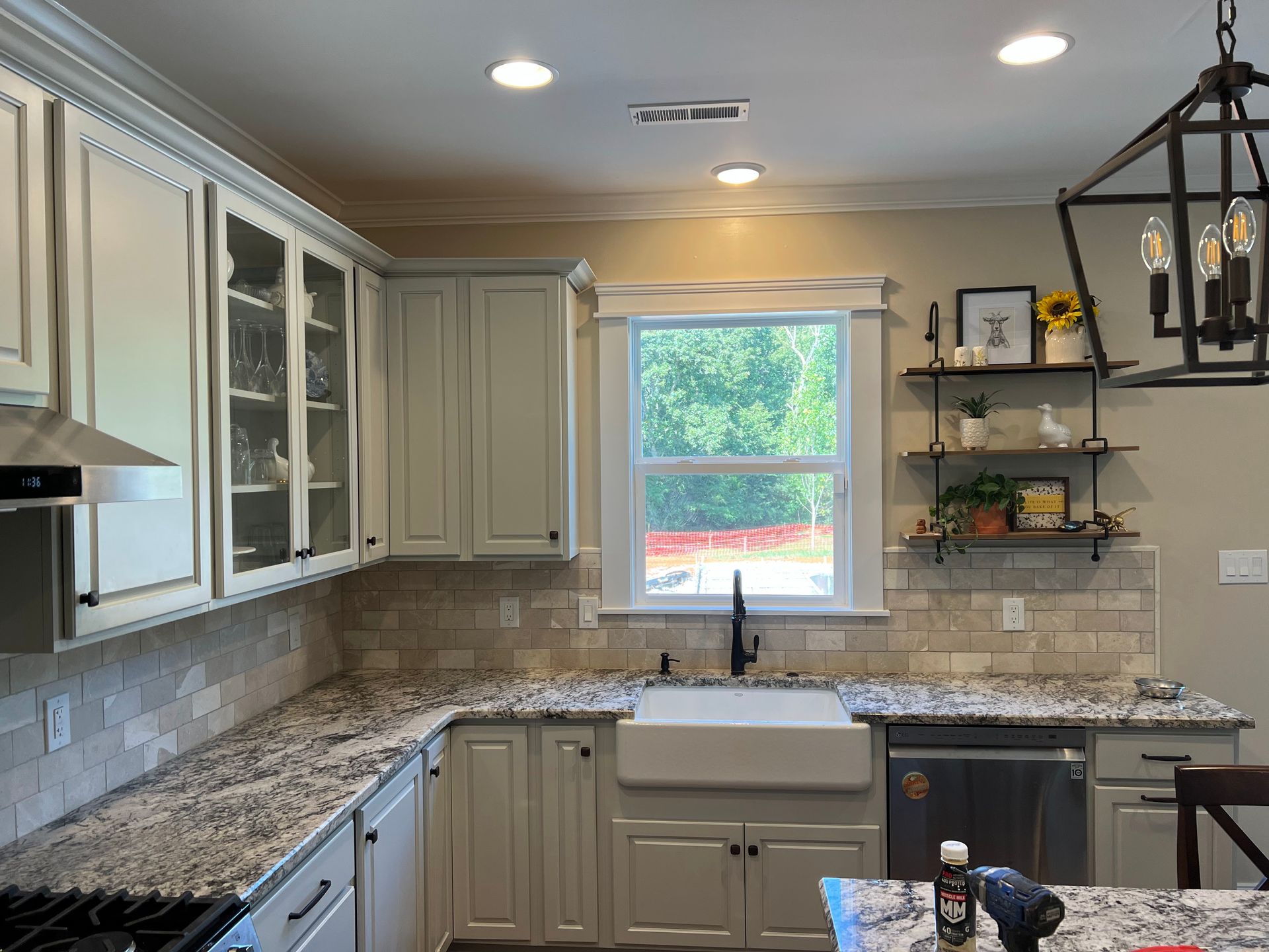 Bright kitchen with granite counters, white cabinets, and a window over the sink.