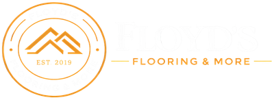 Orange circular logo with mountains and &ldquo;EST 2019&rdquo; beside the text &ldquo;FLOORING & MORE&rdquo;