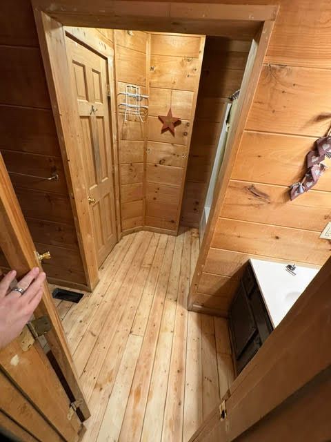 Wood-paneled hallway with a narrow doorway, white sink, and star wall decor
