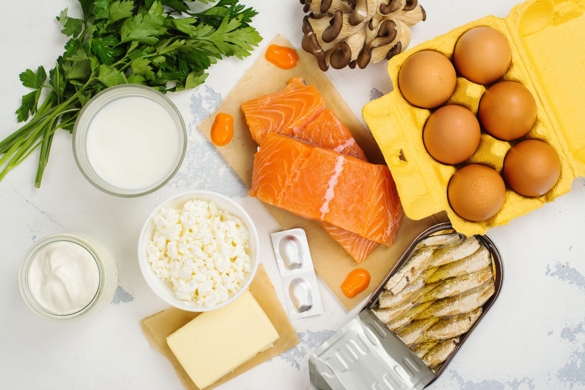 Uma variedade de alimentos contendo vitamina D são dispostos sobre uma mesa.