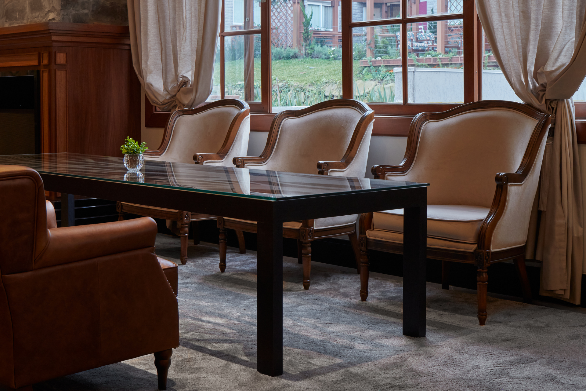 Uma sala de estar com mesa e cadeiras em frente a uma janela.