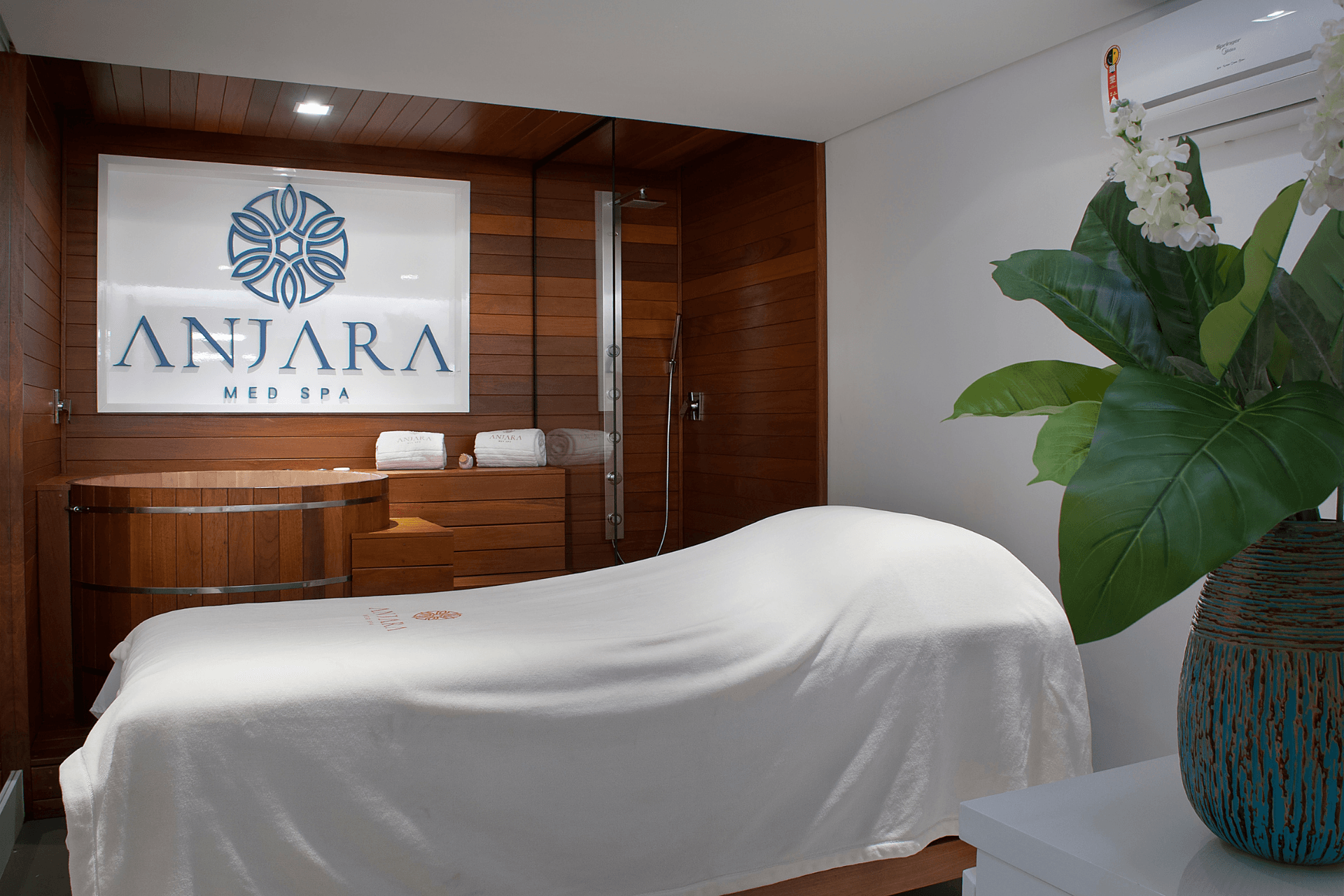Uma mesa de massagem em uma sala com uma placa que diz anjara