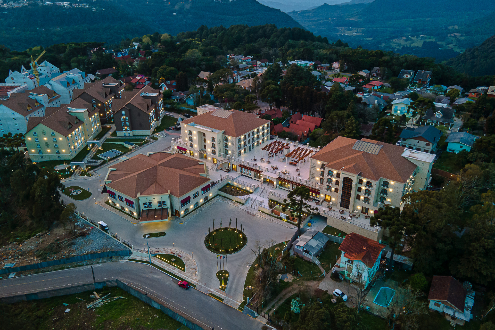 Uma vista aérea de uma cidade com muitos edifícios e árvores ao fundo.