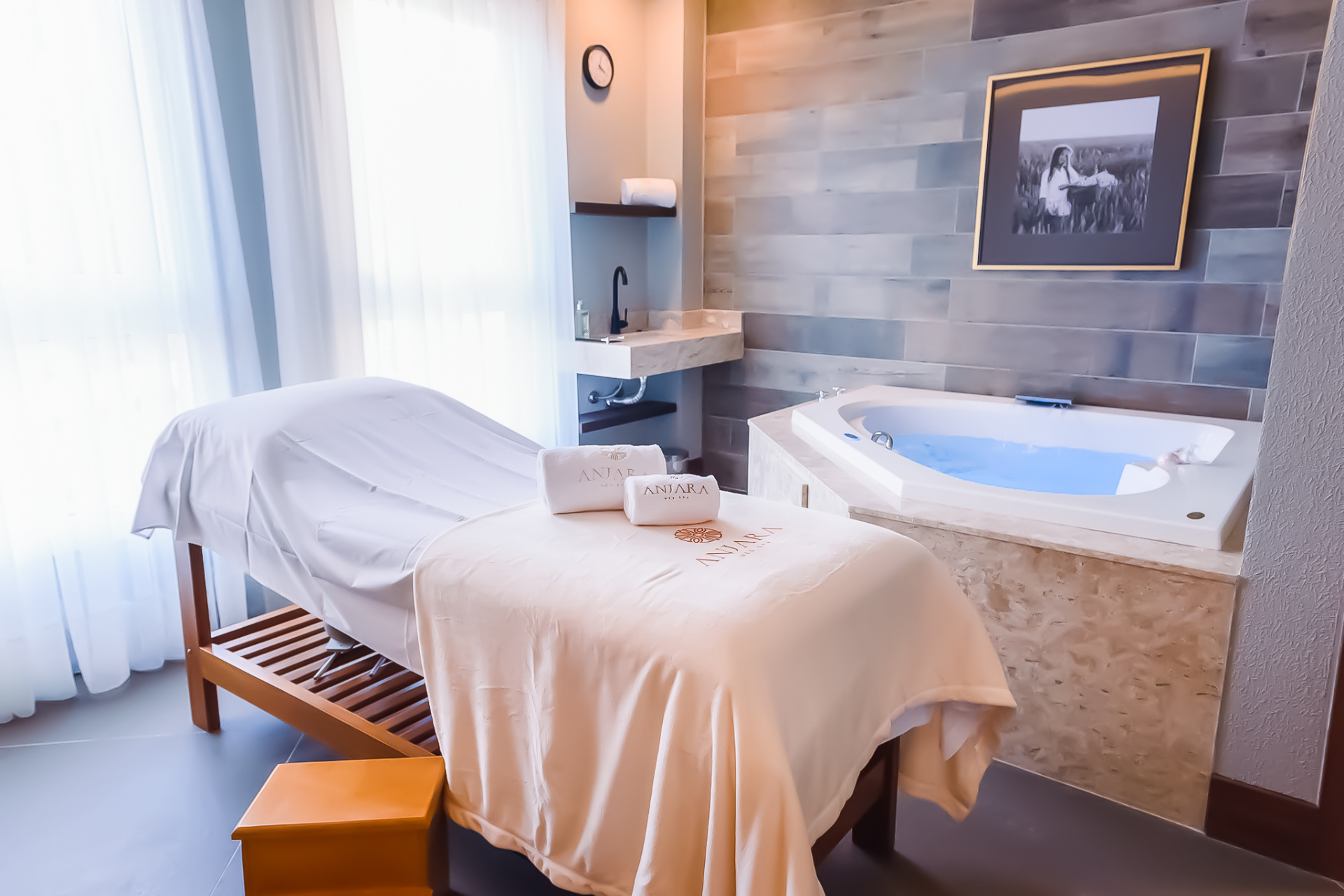 Uma sala de spa com mesa de massagem e banheira jacuzzi.
