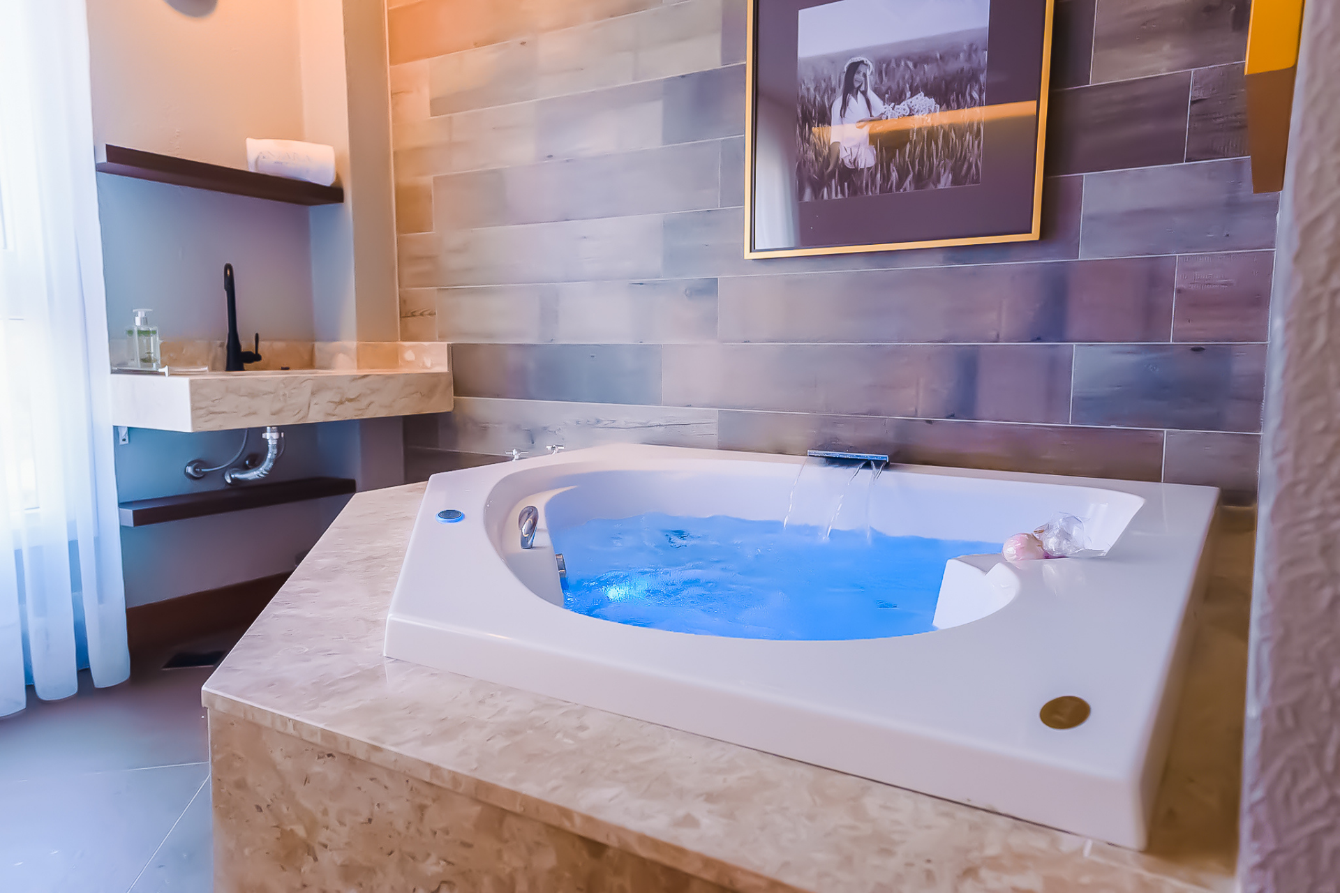 Uma casa de banho com banheira jacuzzi e lavatório.