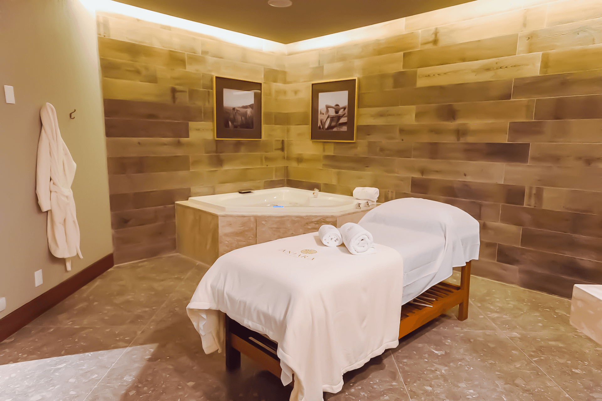 Uma cama de massagem está em uma sala ao lado de uma jacuzzi.