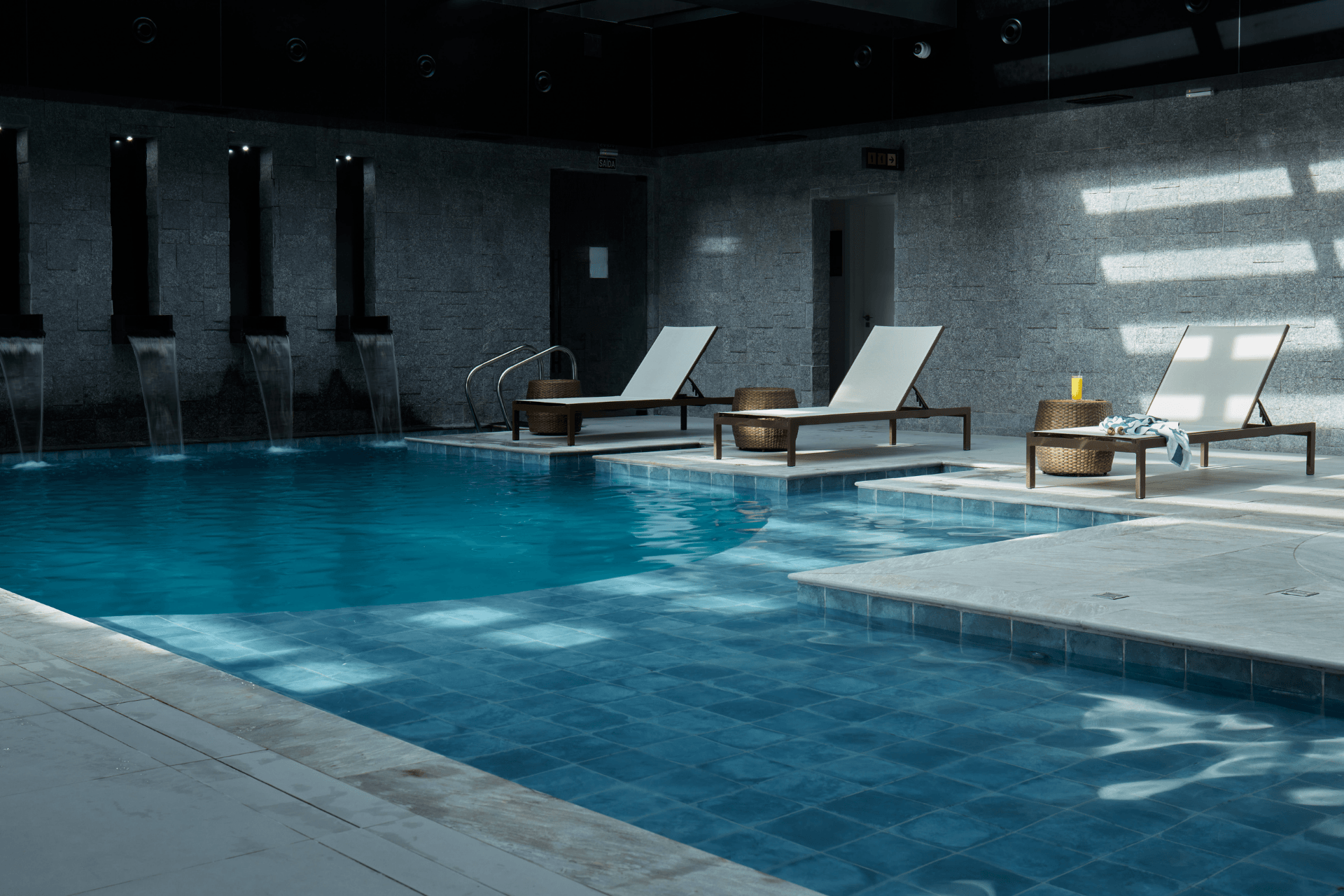 Uma grande piscina coberta com cadeiras ao redor.