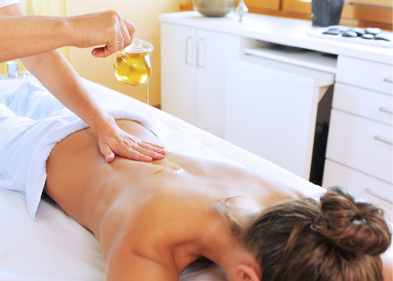 Uma mulher está recebendo uma massagem com óleo nas costas