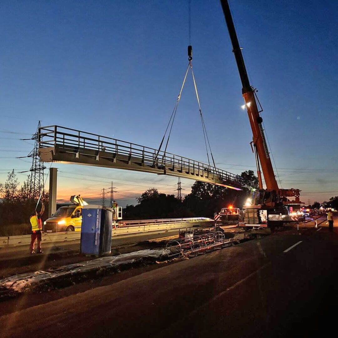 Präzision in der Dämmerung: Scheffknecht Autokran montiert tonnenschweren Überkopfwegweiser