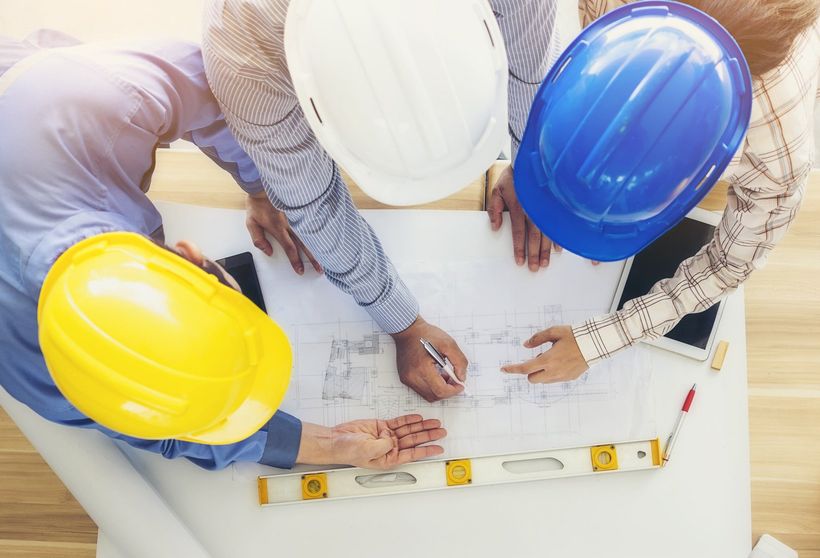 un gruppo di operai edili sta guardando un progetto.