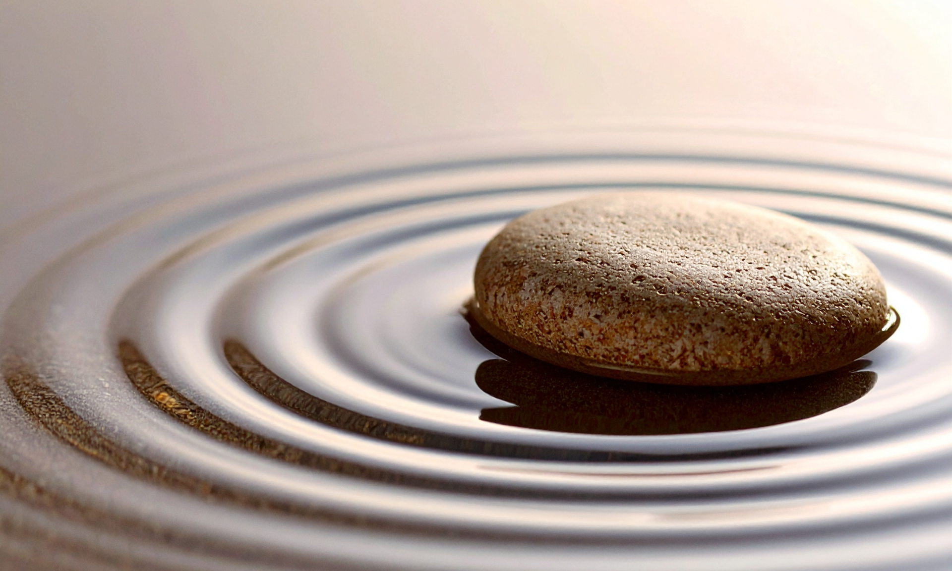 Smooth stone on water with concentric ripples in a calm, minimal scene