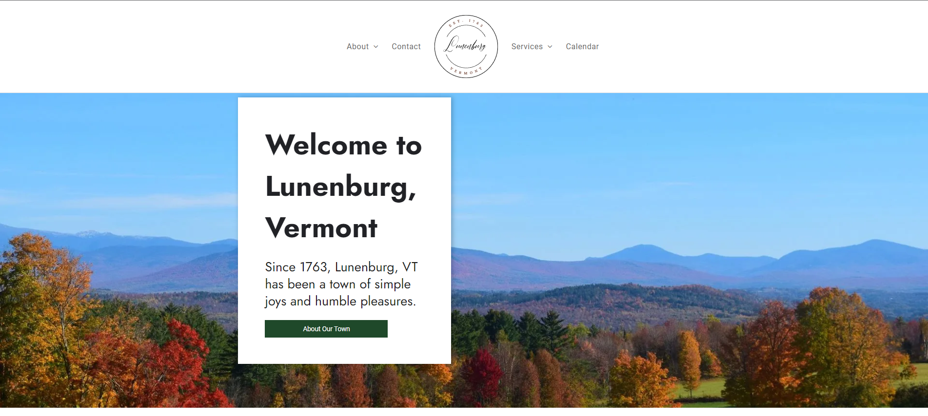 Welcome to Lunenburg, Vermont with a view of fall foliage and mountains.