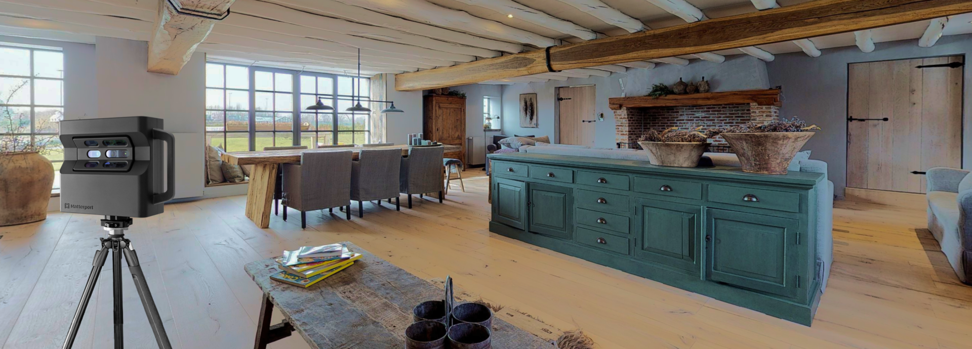 Interior shot of a rustic kitchen with a teal island, wooden beams, and large windows. A 3D scanner is set up on a tripod.