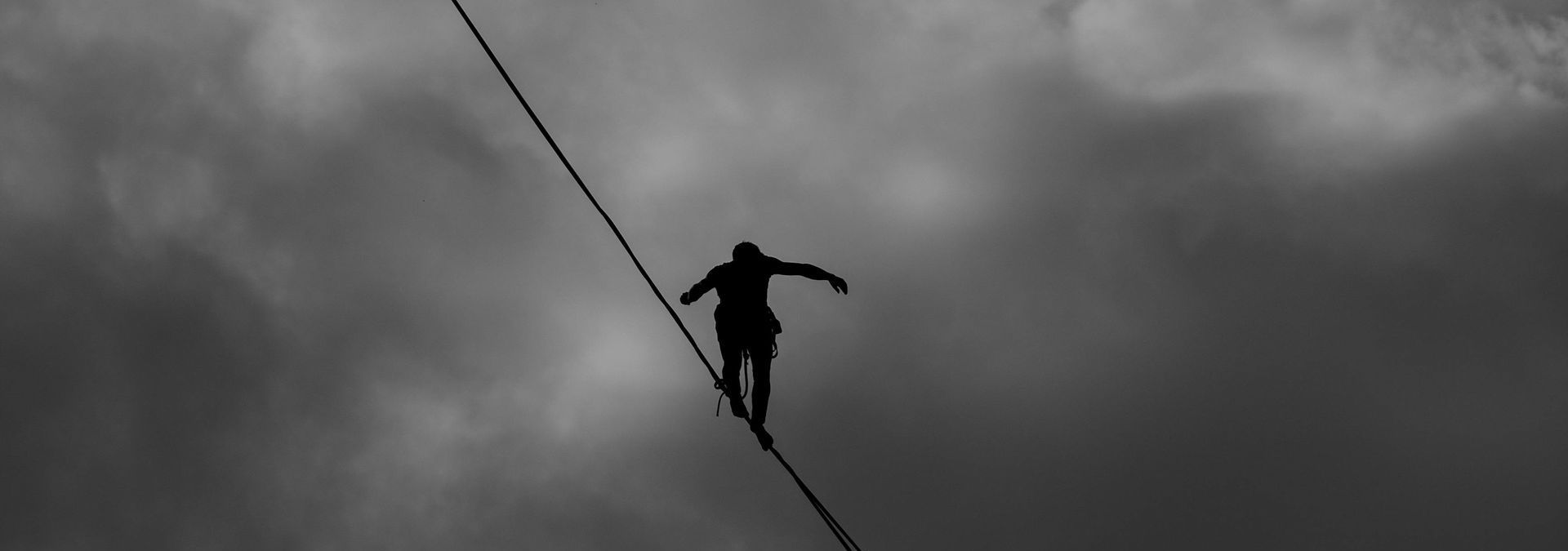 Person balancing on a wire, in a situation that depends directly on strength, precision and choices.
