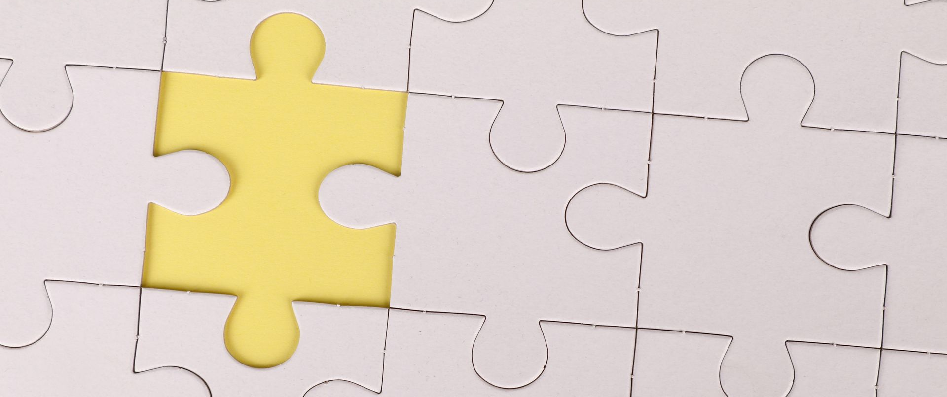 Close-up of a puzzle with one yellow piece missing.