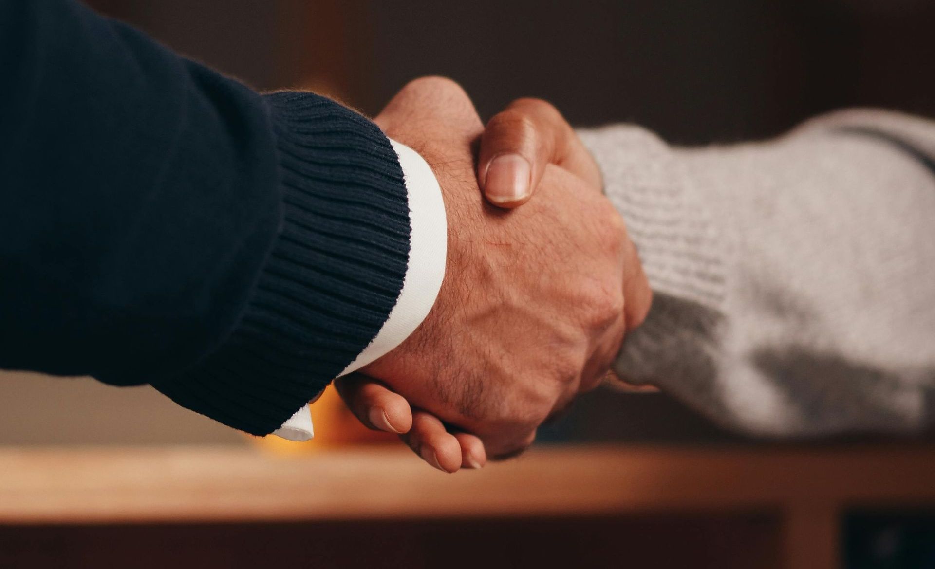 Two people in business dress, exchanging a handshake.