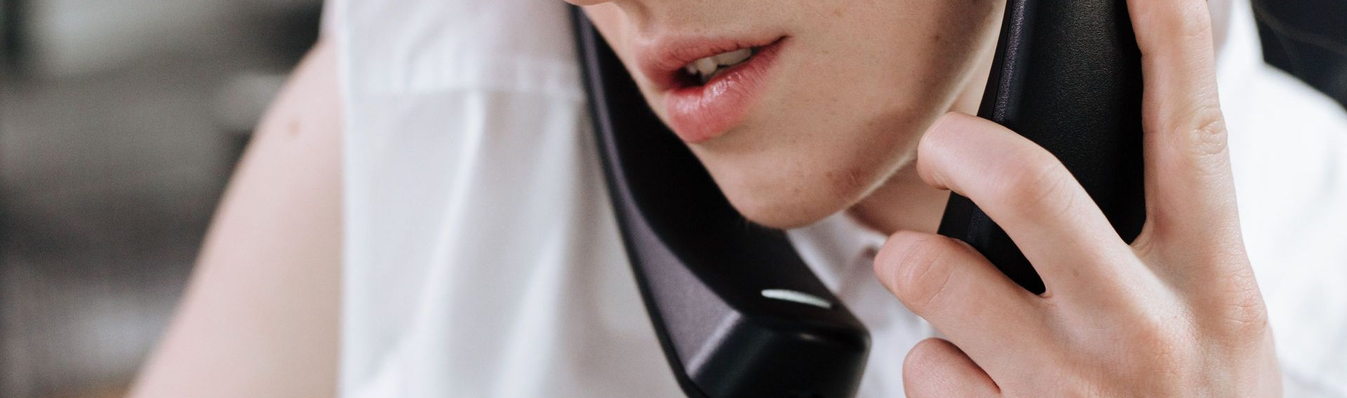 Person speaking on two phones at once representing lead follow-up and customer communication.