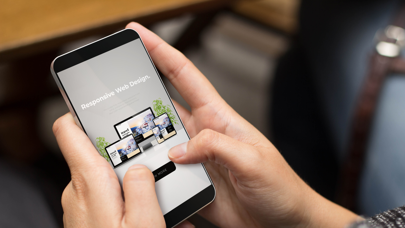 A person is holding a cell phone in their hands that says 'responsive web design'.