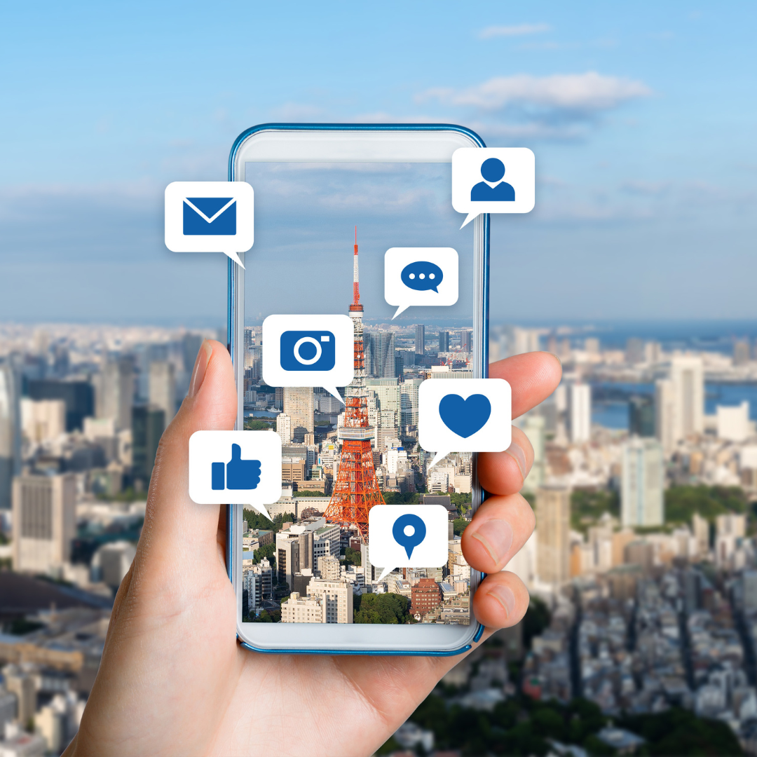 Cell phone with the city focused and blurred in the background with social media icons floating