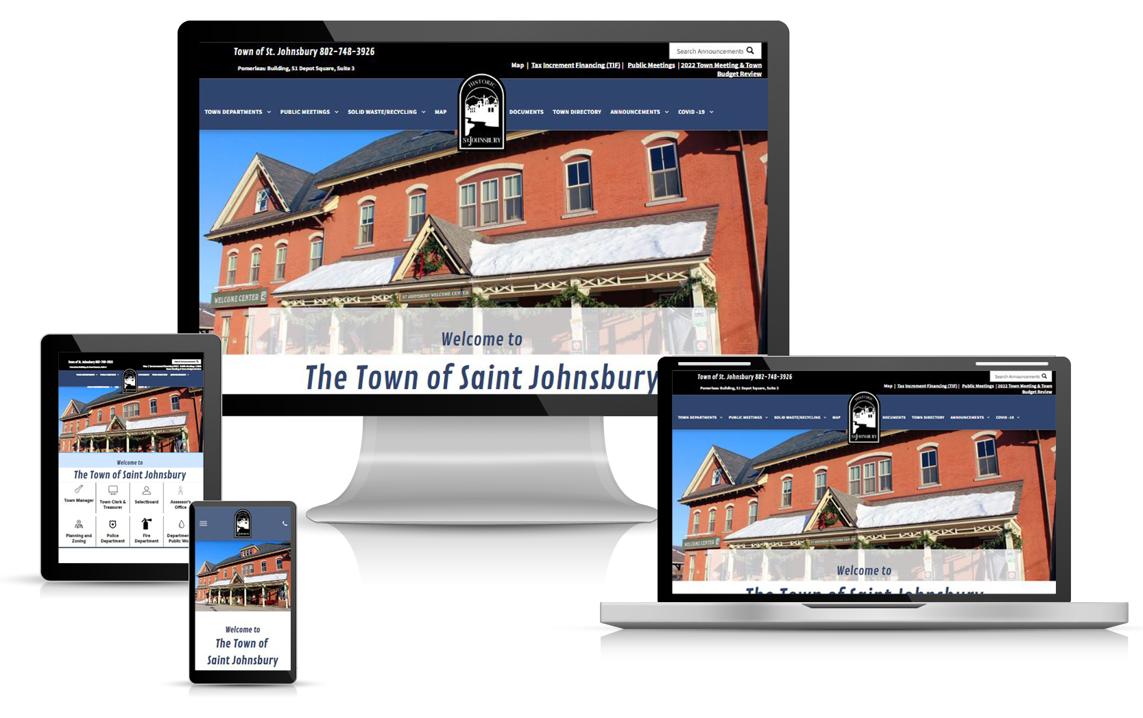 Town of St. Johnsbury website displayed on various devices: monitor, tablet, laptop, and phone.