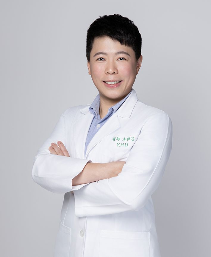 A man in a white coat and tie is smiling for the camera
