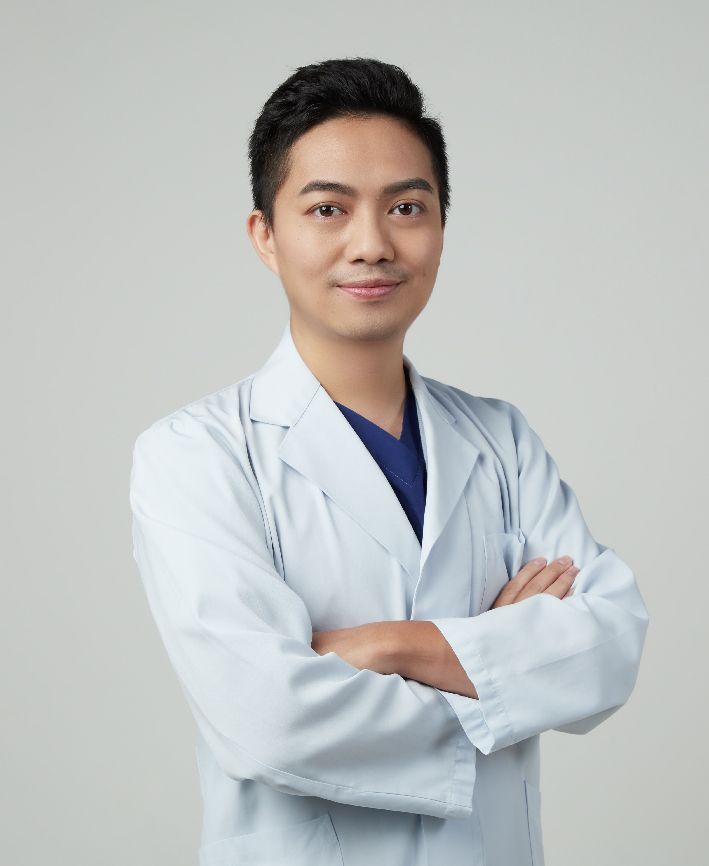 A man in a white lab coat with his arms crossed