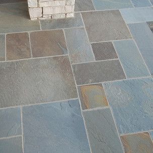 A close up of a tiled floor with a chimney in the background.