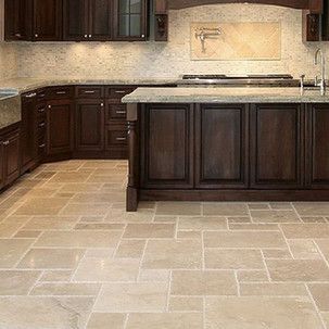 A kitchen with a tiled floor and wooden cabinets.