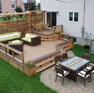 There is a large deck with a table and chairs on it.