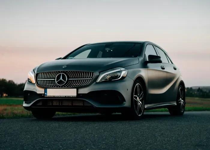 Black Mercedes-Benz sedan parked outdoors at dusk on a road