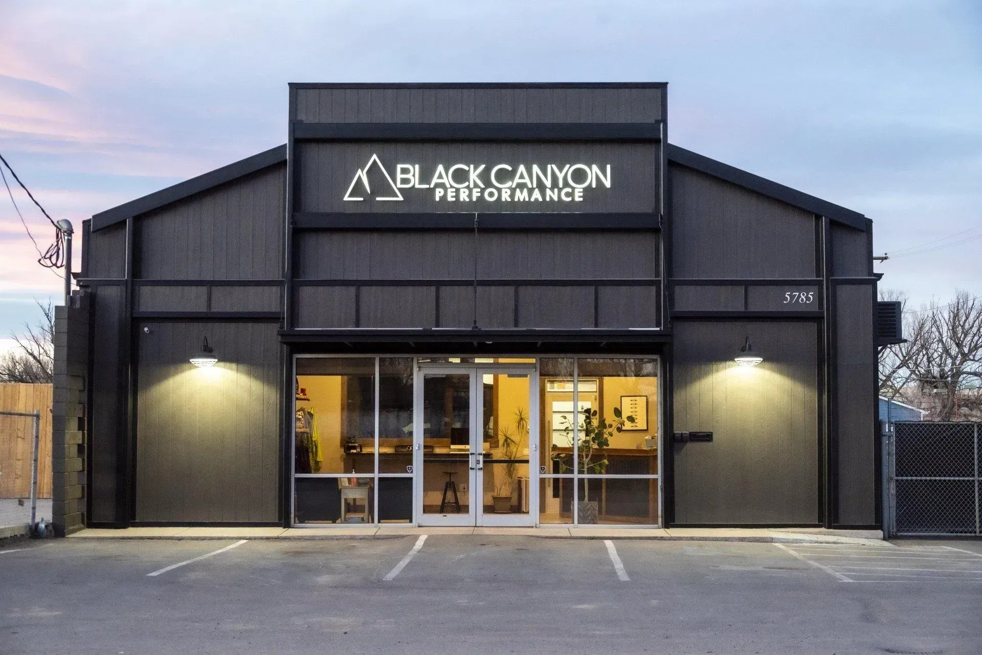 Black Canyon Prosthetics storefront at dusk, with lit entrance and black facade.