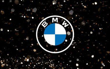 BMW logo on a black background with scattered light particles