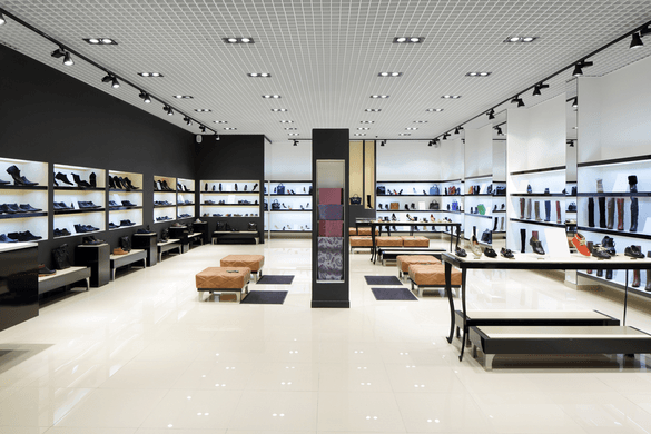 A shoe store filled with lots of shoes and furniture.