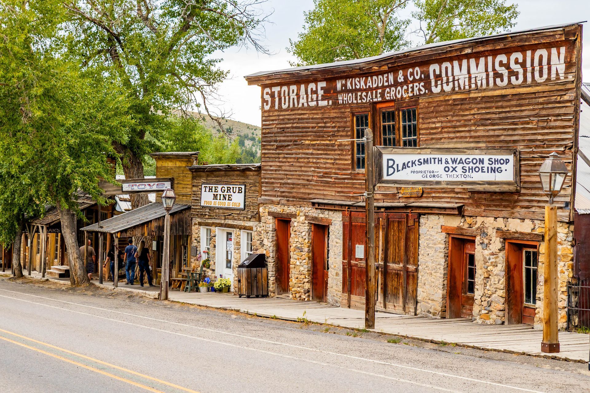 Old western-style storefronts with faded signs along a quiet street in a small town