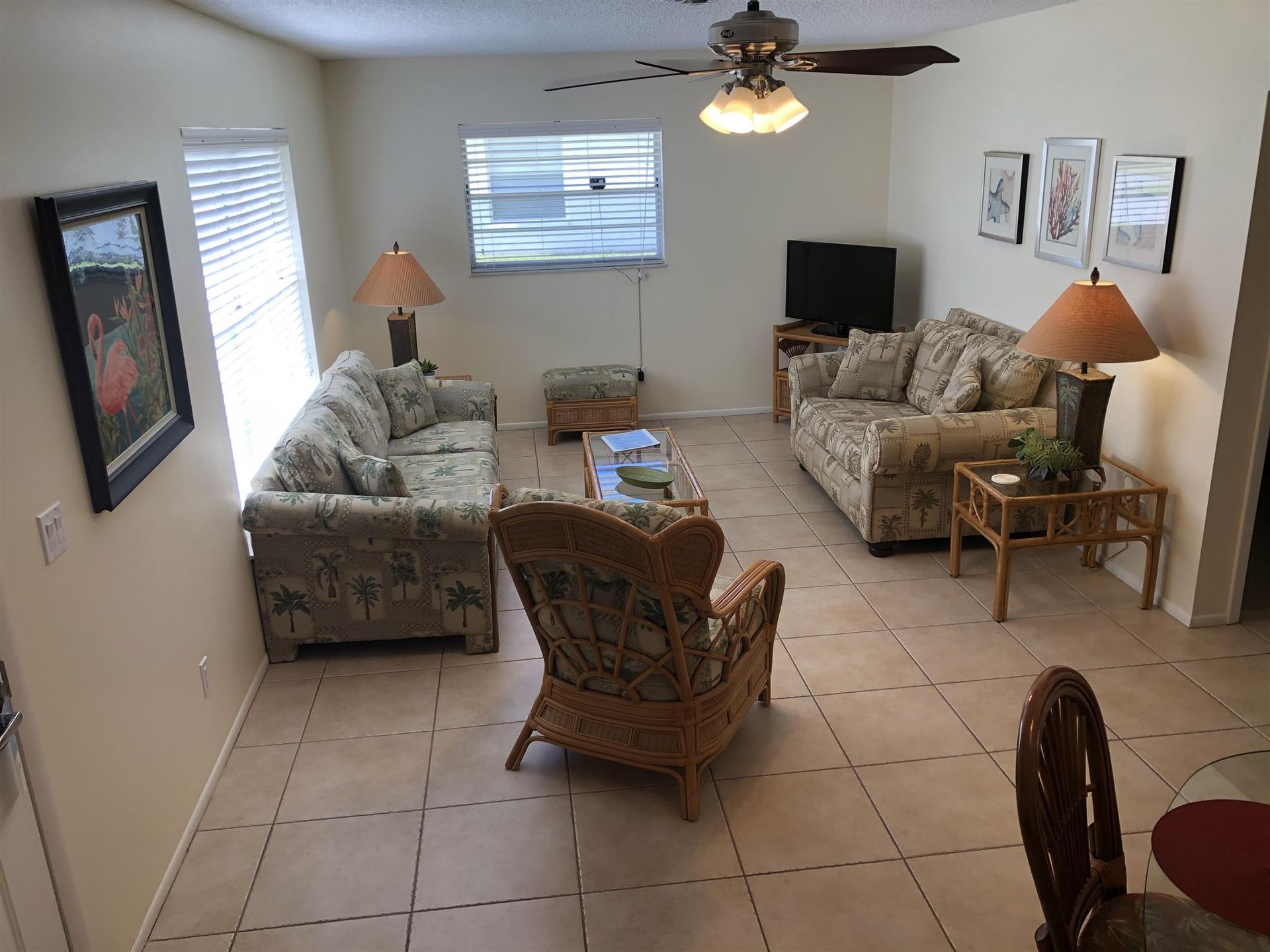 A living room with a couch and chairs and a ceiling fan