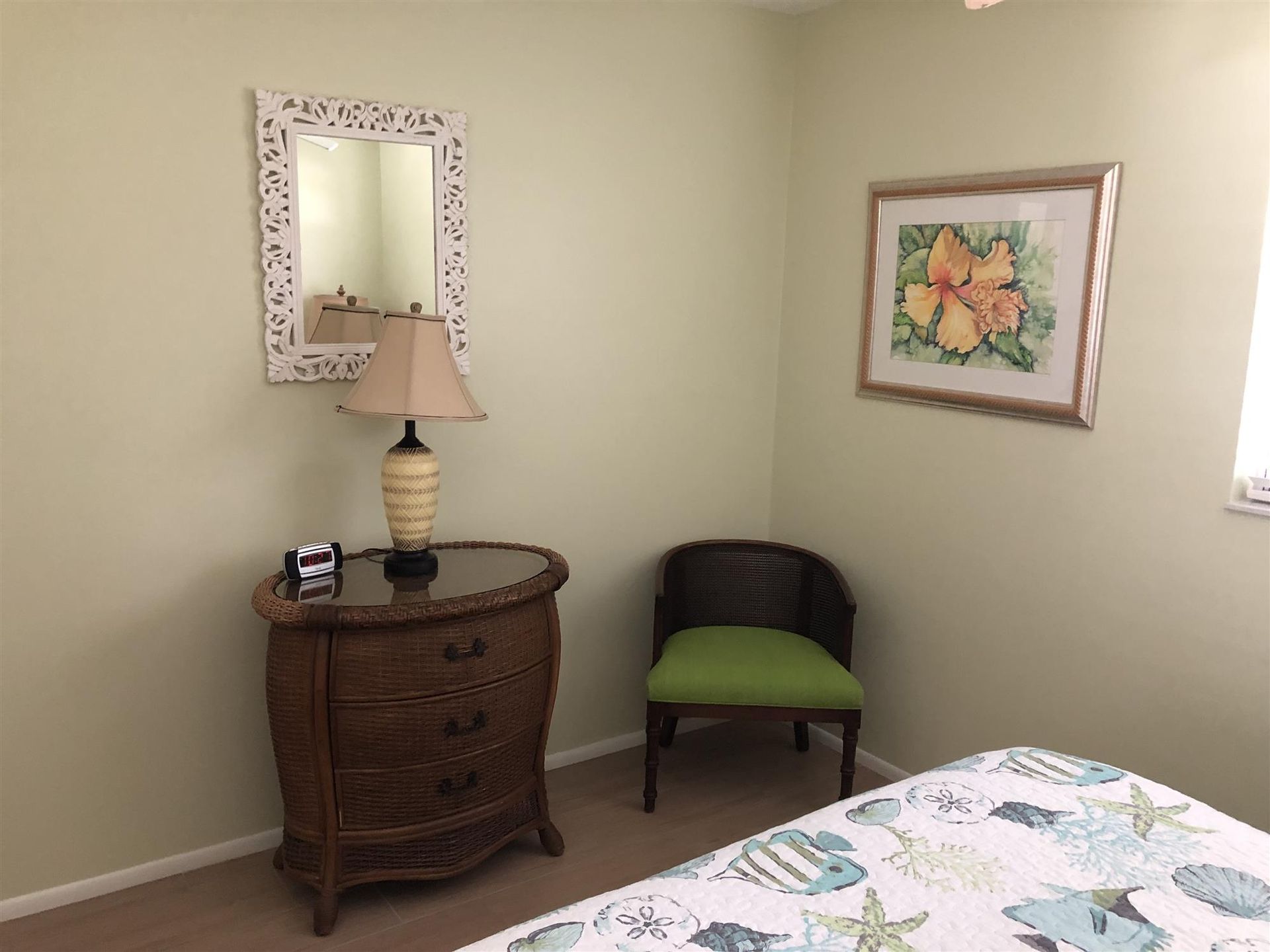 A bedroom with a bed , dresser , chair , lamp and mirror.