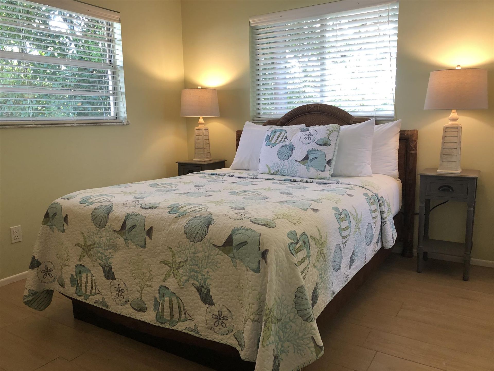A bedroom with a bed , two lamps and a window
