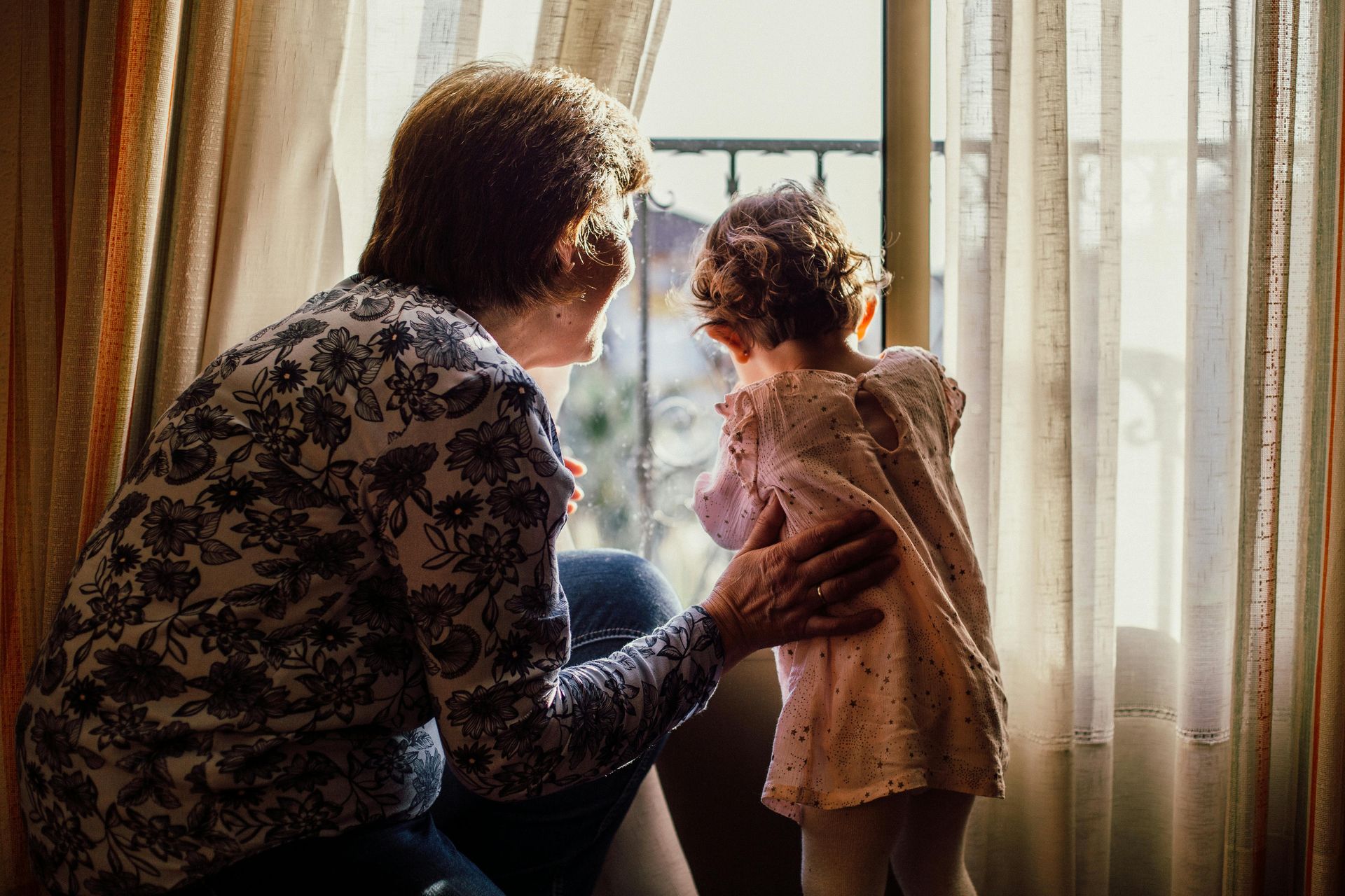 Woman looking out the window with her granddaughter