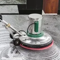 A person is using a machine to clean a marble floor.