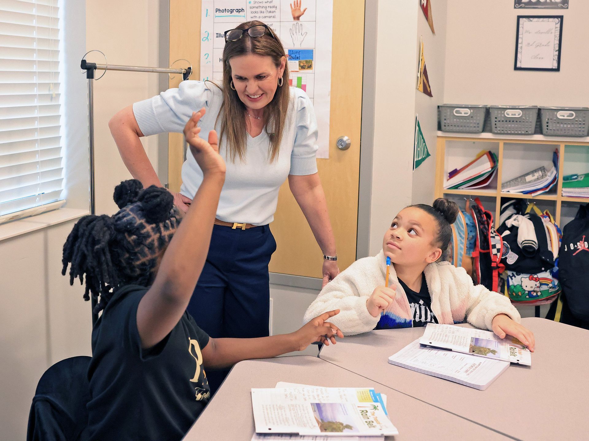 Gov. Sarah Sanders visits with students in a classroom.
