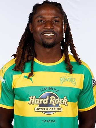 Lucky Mkosana in a green and yellow jersey, smiling at the camera, with dreadlocks.