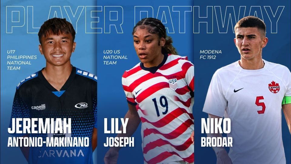 Three soccer players in blue, red, and white jerseys on a