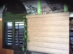 Una pared de madera con una ventana y contraventanas.