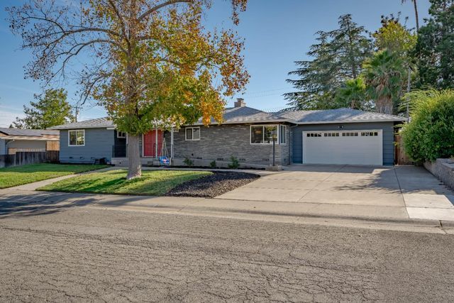 A house with a garage and a tree in front of it | Buy a Home in Greenhaven-Pocket, Sacramento, CA